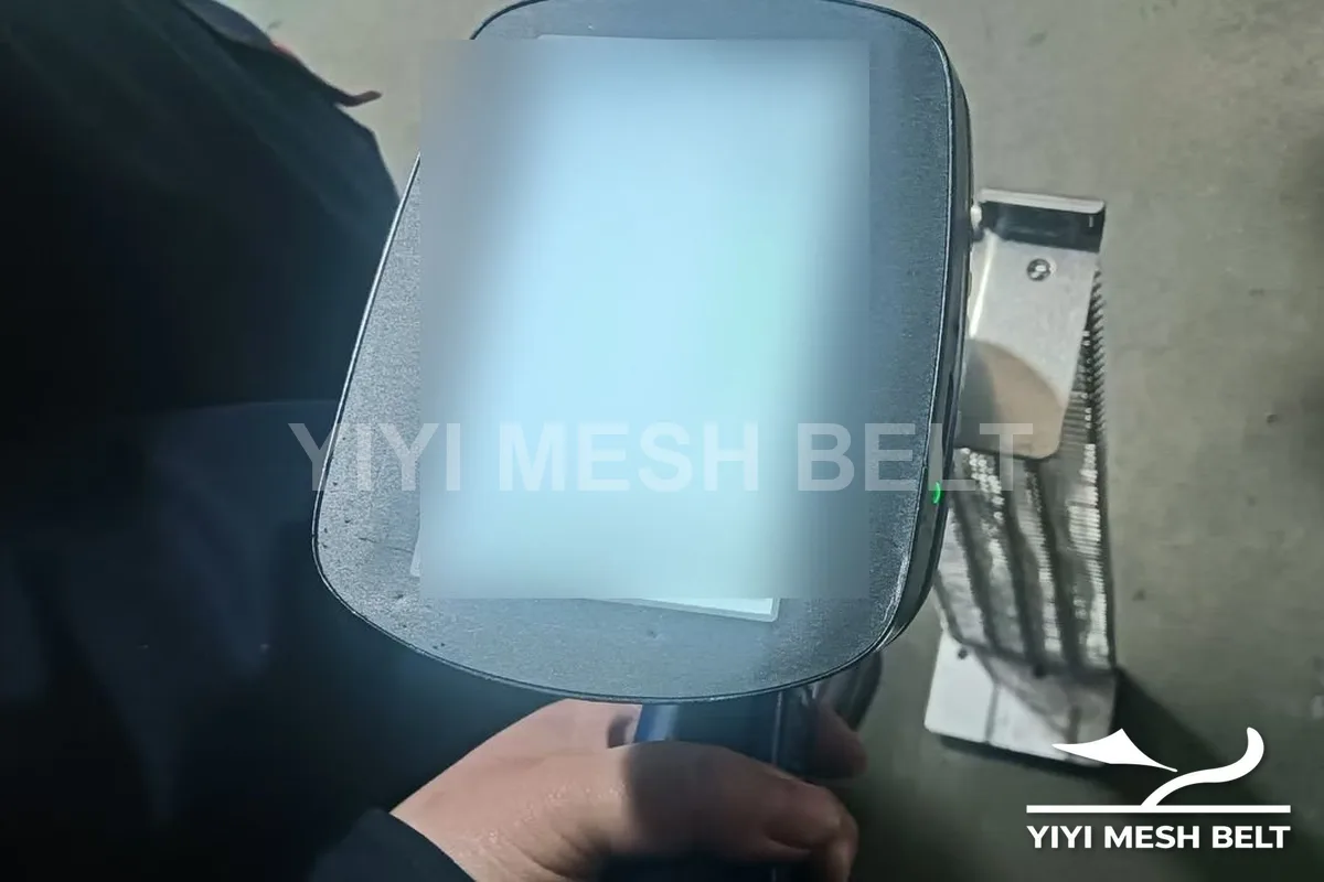 YIYI Mesh Belt inspector checking the alloy composition of a self-stacking belt side link with a handheld analyzer